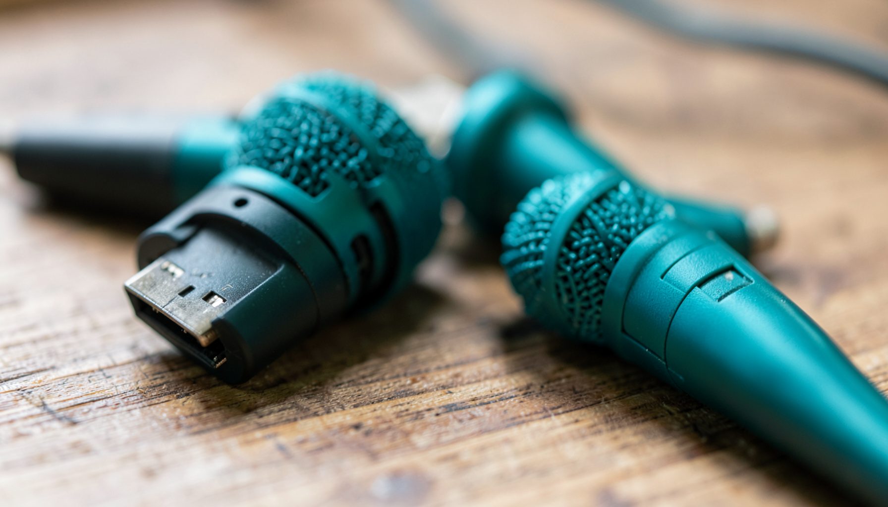 Selection of USB microphones on a wooden desk surface, soft natural light