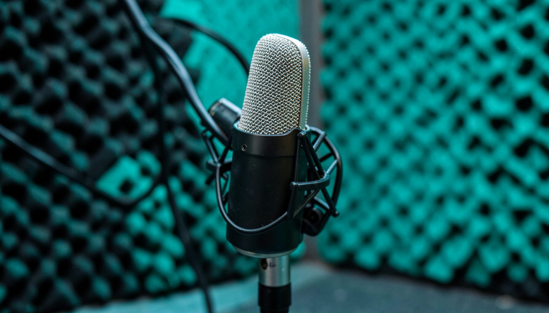 Podcast studio setup with a dynamic microphone and acoustic foam panels