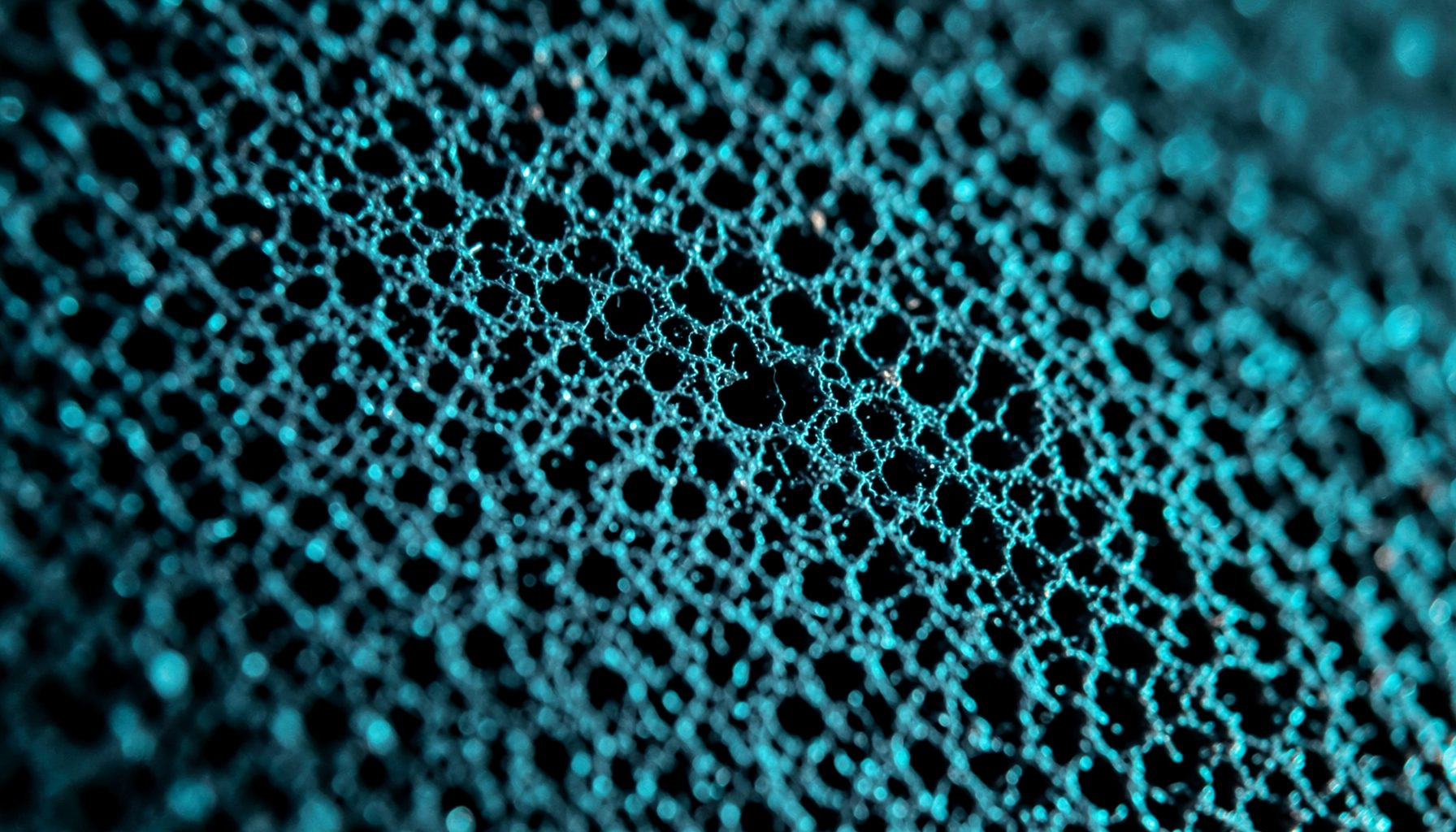 Extreme close-up of black foam windscreen texture, dense porous surface